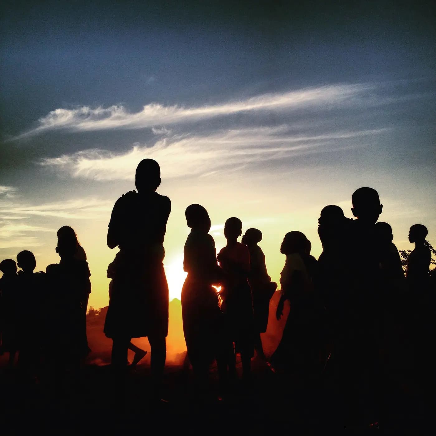Illustration — silhouettes d'un rassemblement communautaire en Afrique australe au coucher du soleil